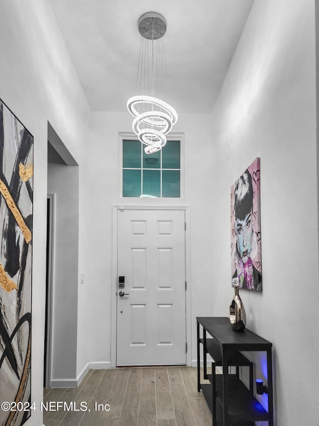 foyer with hardwood / wood-style flooring and a notable chandelier