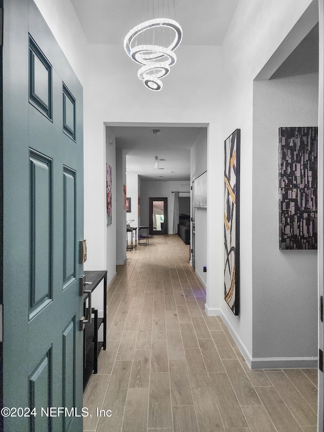 hallway with a chandelier and hardwood / wood-style flooring