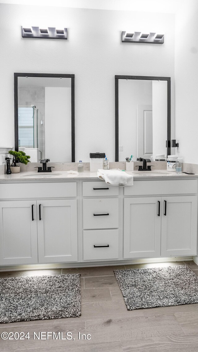 bathroom featuring vanity, wood-type flooring, and walk in shower