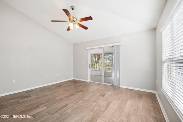 spare room featuring a textured ceiling, ceiling fan, light hardwood / wood-style floors, and vaulted ceiling