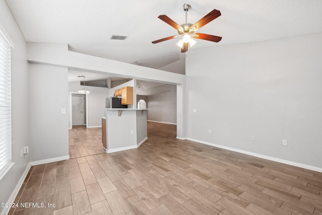 unfurnished living room with a textured ceiling, ceiling fan, lofted ceiling, and light wood-type flooring