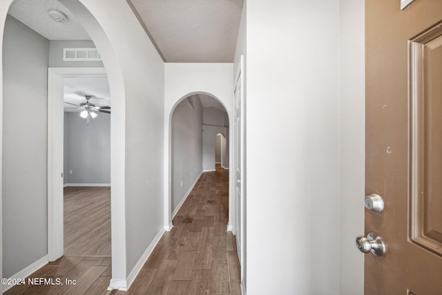 hall featuring hardwood / wood-style floors and a textured ceiling