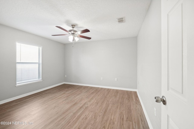 spare room with ceiling fan, light hardwood / wood-style floors, and a textured ceiling