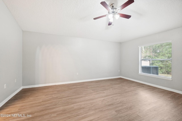 spare room with ceiling fan, a textured ceiling, and light wood-type flooring