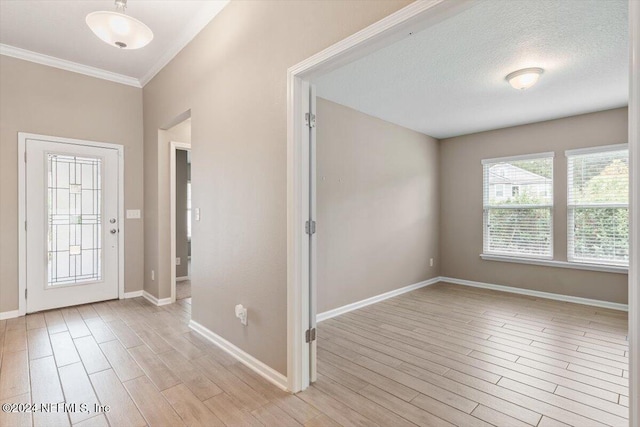 entryway featuring ornamental molding, a textured ceiling, and light wood-type flooring