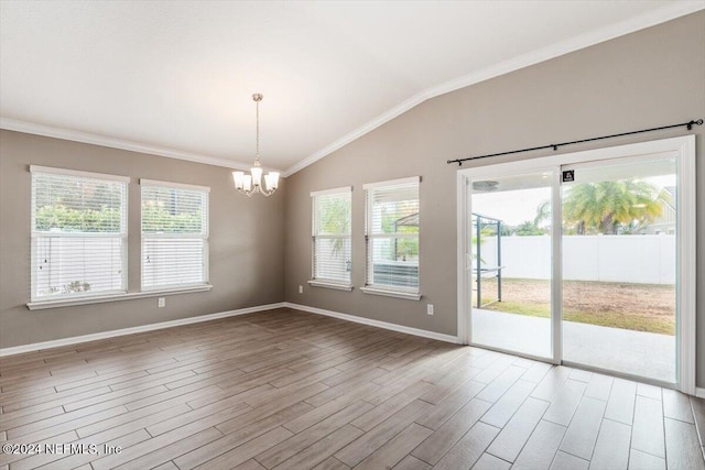 empty room featuring wood-type flooring, an inviting chandelier, ornamental molding, and lofted ceiling