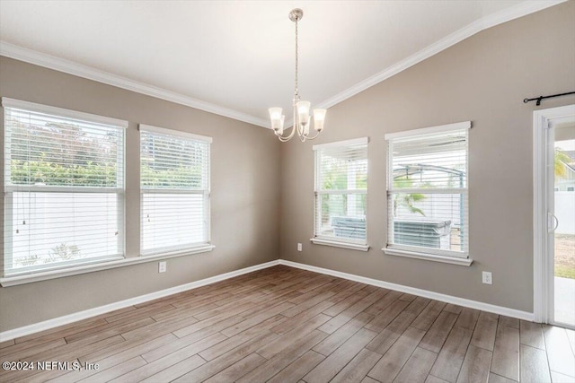 unfurnished room featuring a notable chandelier, plenty of natural light, and light hardwood / wood-style floors