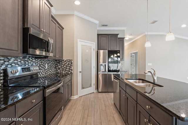 kitchen with appliances with stainless steel finishes, dark brown cabinets, crown molding, sink, and hanging light fixtures