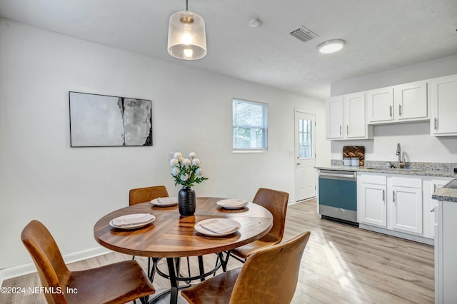 dining room featuring light wood-type flooring and sink