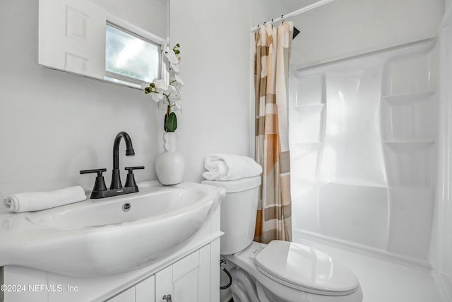 bathroom featuring curtained shower, vanity, and toilet