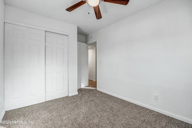 unfurnished bedroom with ceiling fan, carpet floors, and a closet