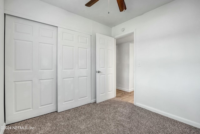 unfurnished bedroom featuring light carpet, a closet, and ceiling fan