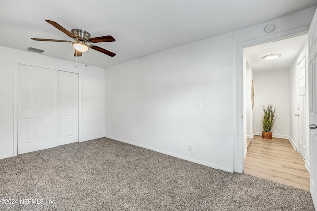 unfurnished bedroom with ceiling fan, a closet, and light colored carpet