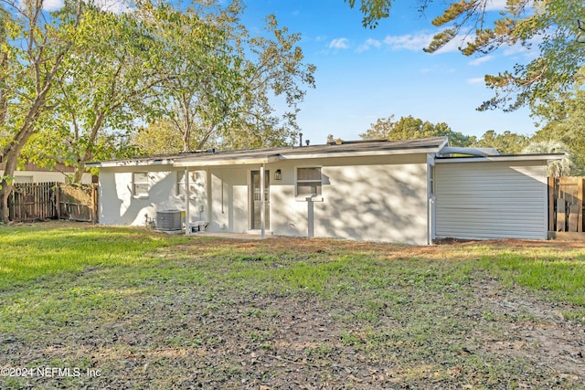 rear view of property with a lawn and central AC unit