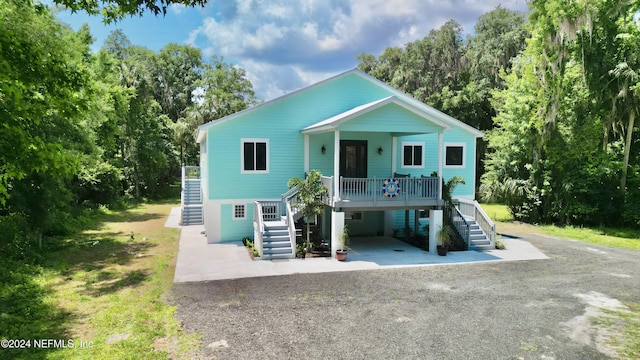 coastal inspired home with covered porch and a carport