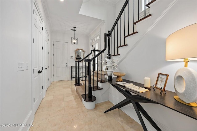 entrance foyer with an inviting chandelier and ornamental molding