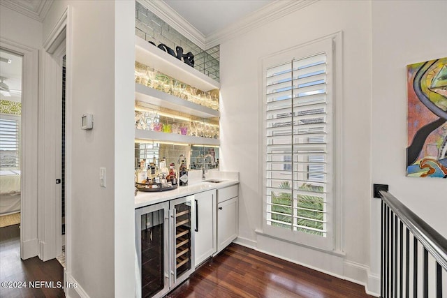 bar with wine cooler, plenty of natural light, and dark wood-type flooring