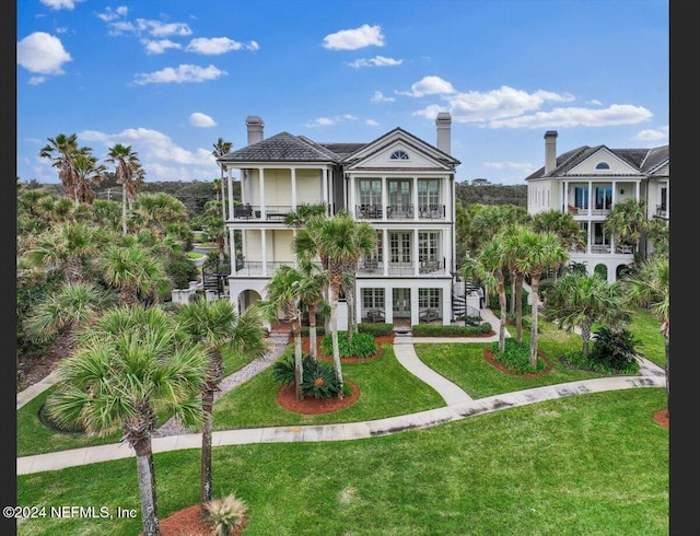 view of front of property with a balcony, a front yard, and french doors