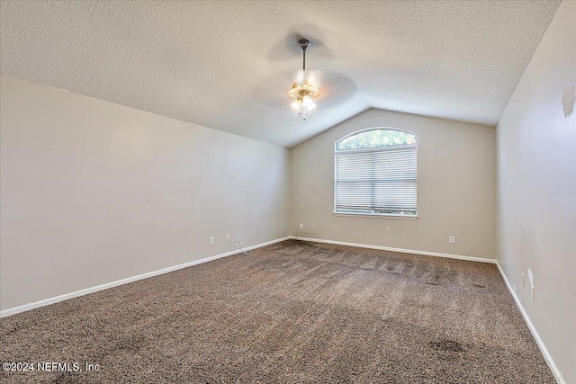 carpeted spare room featuring a textured ceiling, ceiling fan, and lofted ceiling