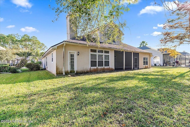 rear view of property featuring a lawn