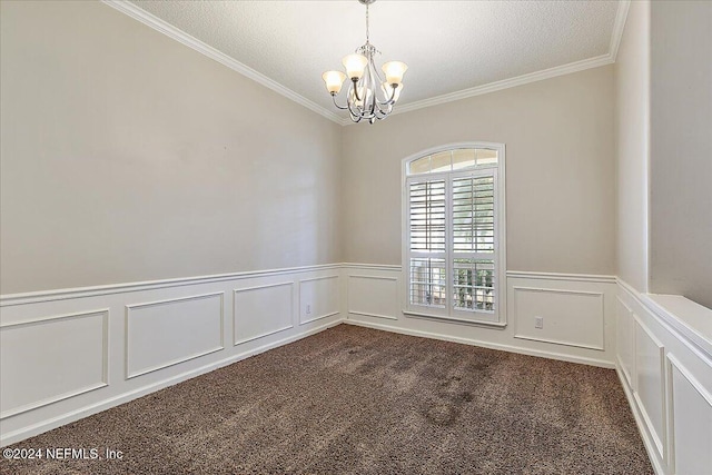 empty room featuring a chandelier, a textured ceiling, dark carpet, and ornamental molding