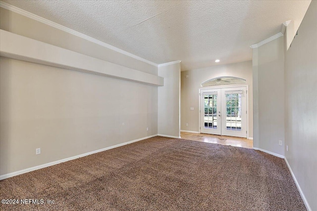 spare room featuring crown molding, french doors, carpet floors, and a textured ceiling