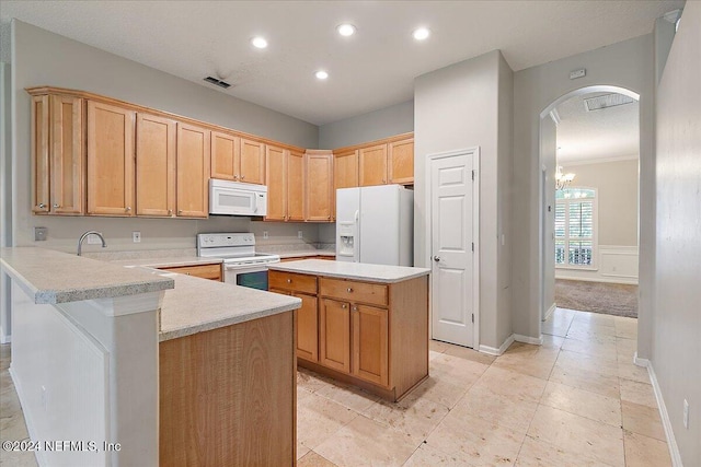 kitchen with kitchen peninsula, a textured ceiling, white appliances, an inviting chandelier, and a kitchen island