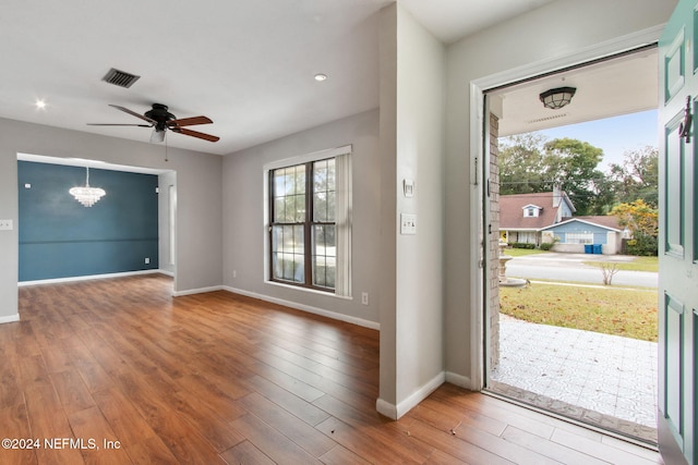 interior space with wood-type flooring and ceiling fan with notable chandelier