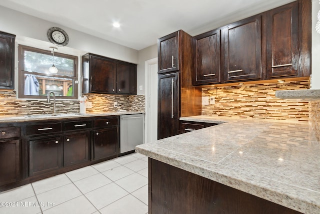 kitchen featuring dishwasher, backsplash, sink, decorative light fixtures, and dark brown cabinetry