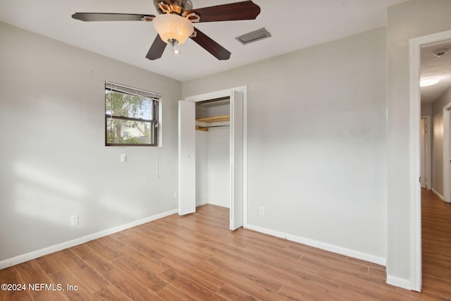 unfurnished bedroom featuring a closet, light hardwood / wood-style flooring, and ceiling fan