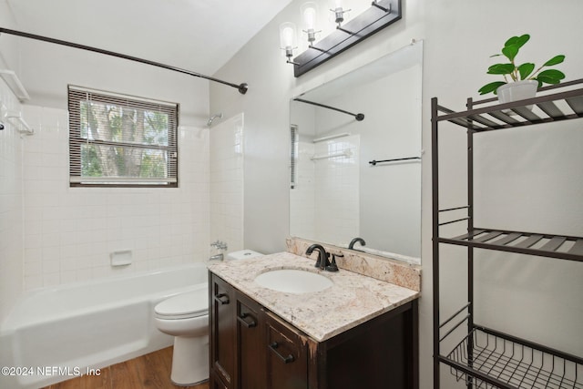 full bathroom featuring tiled shower / bath, toilet, vanity, and hardwood / wood-style flooring