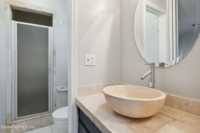 bathroom with vanity, toilet, and a shower with shower door