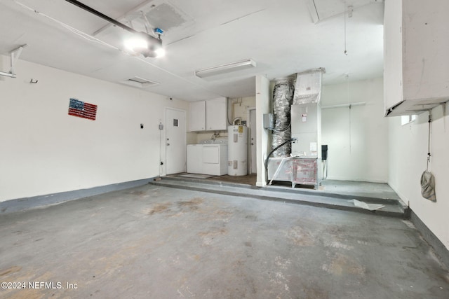 garage featuring washing machine and dryer, heating unit, and water heater