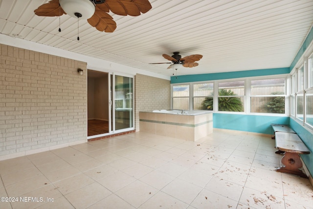 unfurnished sunroom with ceiling fan