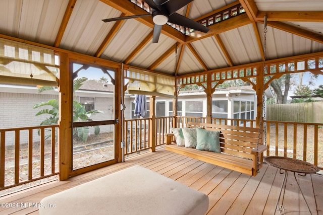 sunroom with ceiling fan, plenty of natural light, and vaulted ceiling