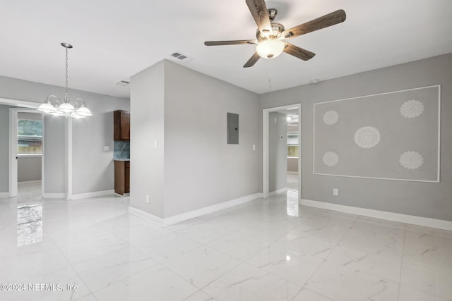 spare room featuring ceiling fan with notable chandelier and electric panel