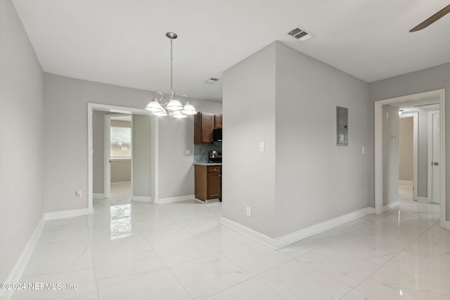 unfurnished dining area with ceiling fan with notable chandelier