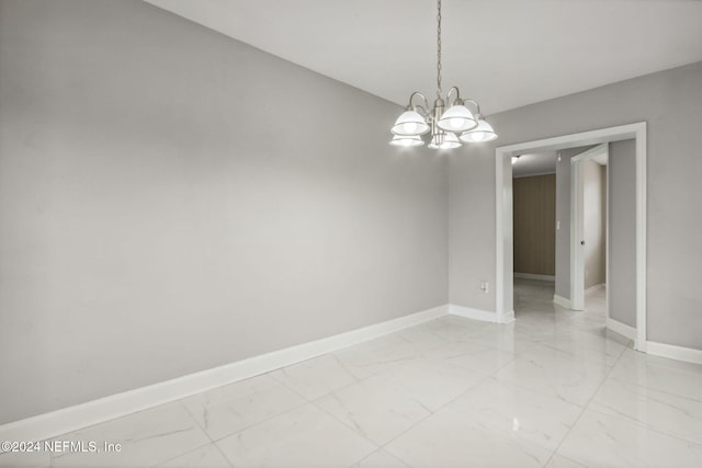 unfurnished room featuring a chandelier