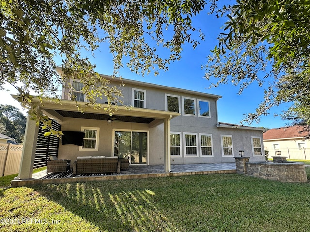 rear view of house featuring outdoor lounge area, a yard, a patio, and ceiling fan