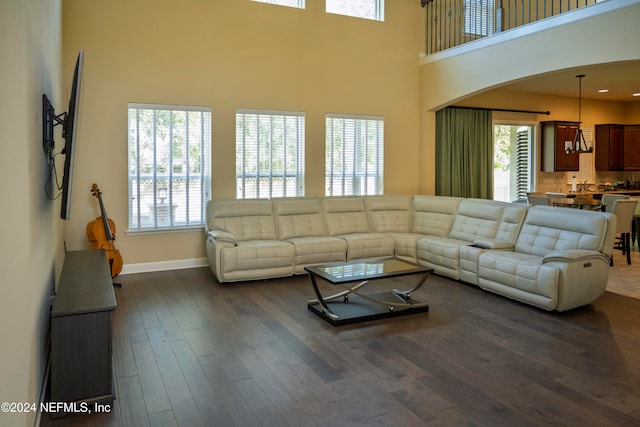 living room with dark hardwood / wood-style flooring, plenty of natural light, and a high ceiling