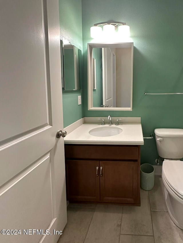 bathroom featuring tile patterned flooring, vanity, and toilet