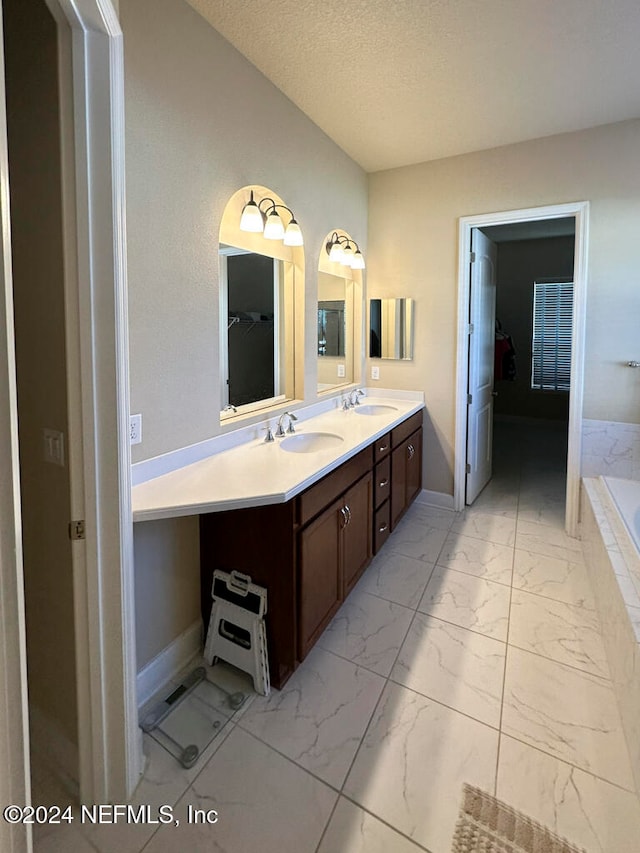 bathroom with vanity, a textured ceiling, and a washtub