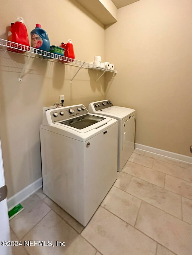 laundry area with light tile patterned floors and washer and dryer