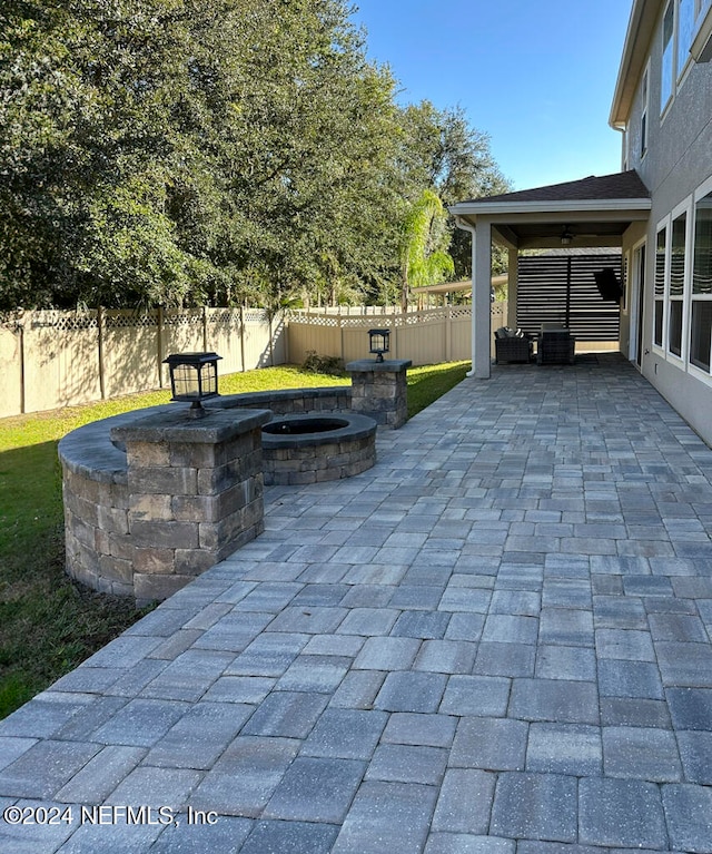 view of patio featuring ceiling fan and an outdoor fire pit