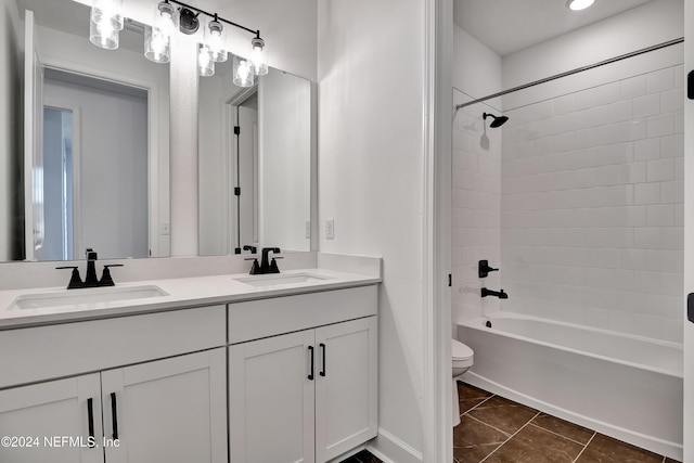 full bathroom with tile patterned flooring, vanity,  shower combination, and toilet