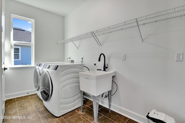 laundry room with dark tile patterned flooring and washer and dryer