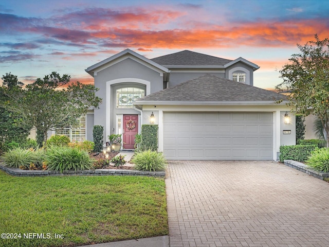 front of property with a garage and a yard