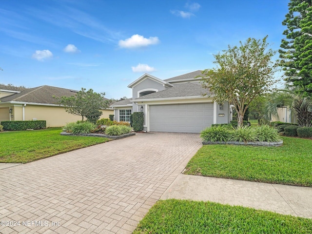 view of front of home with a front yard and a garage