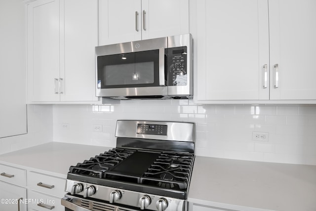 kitchen featuring backsplash, appliances with stainless steel finishes, and white cabinets