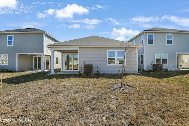 rear view of property featuring cooling unit, a patio area, and a lawn